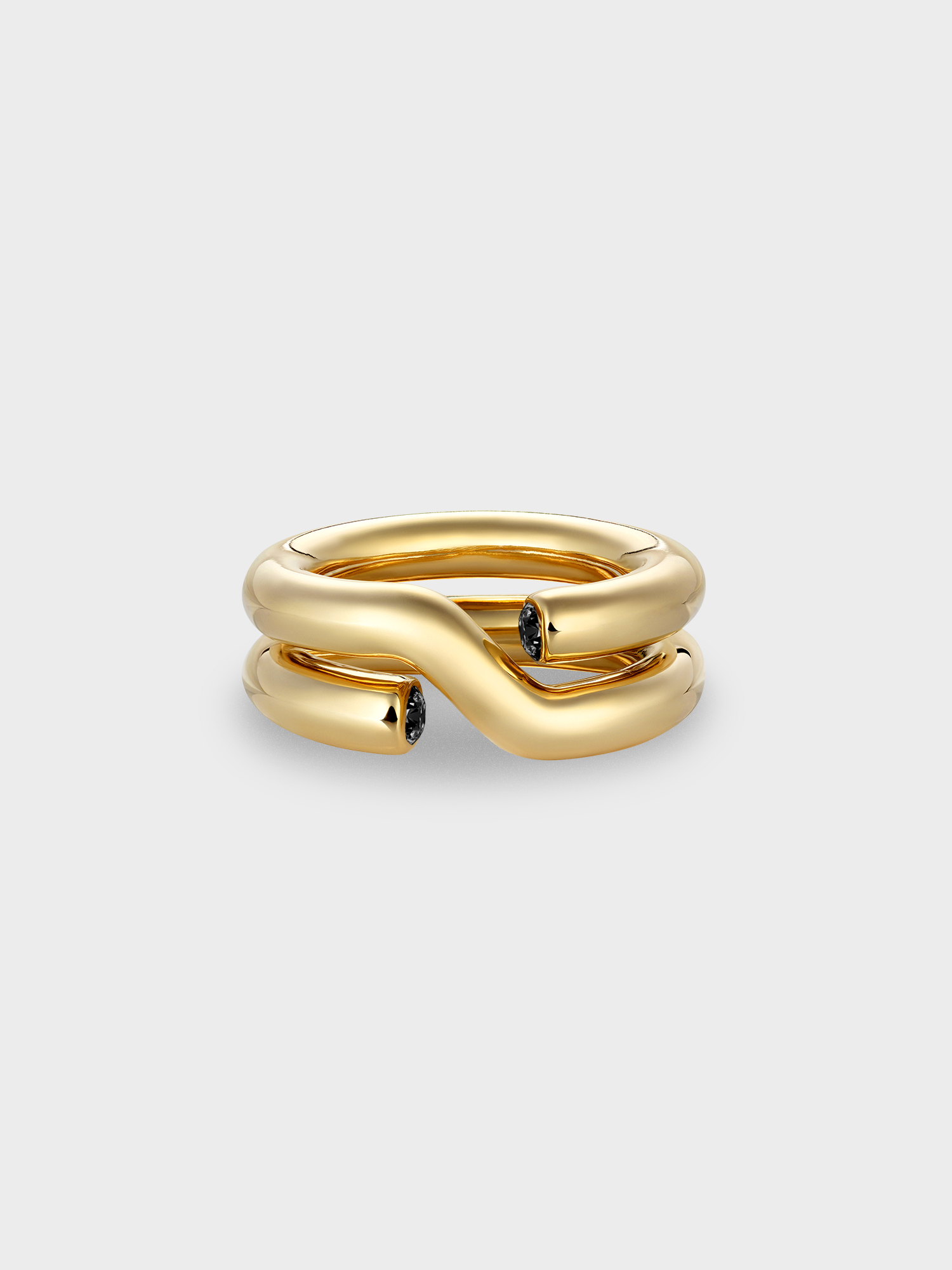 Gold ring with black diamonds on a light gray background.