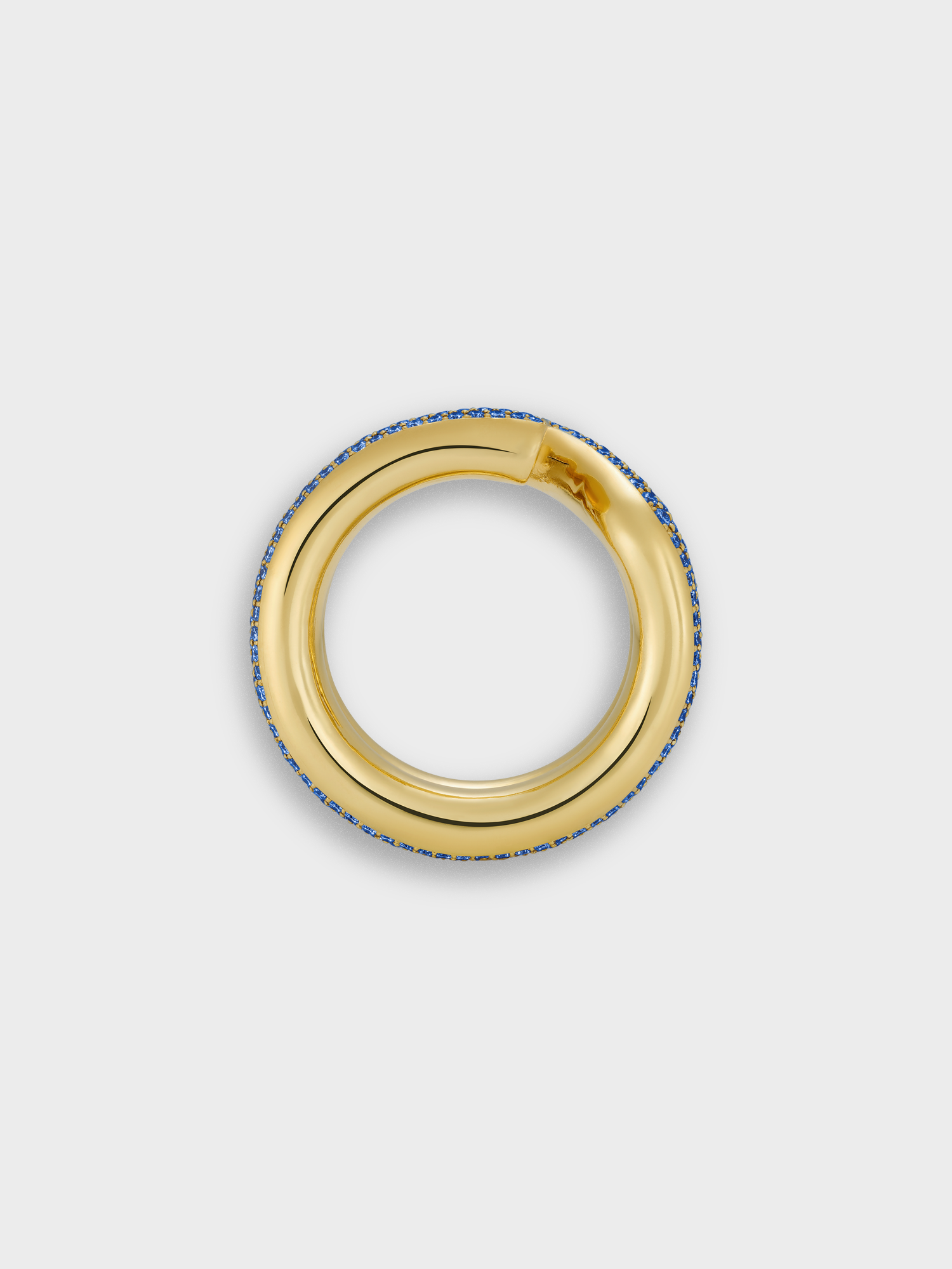 Gold keyring ring with sapphire pave on a light gray background